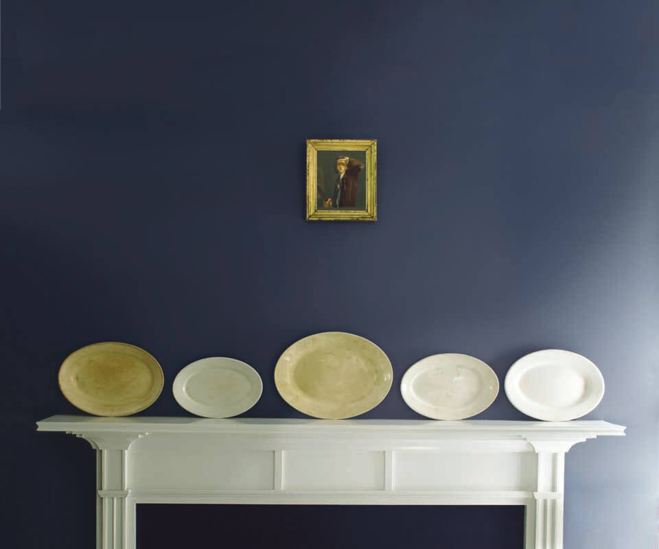 Plates on a white mantelpiece Plates on a white mantelpiece beneath a small portrait on a blue wall.