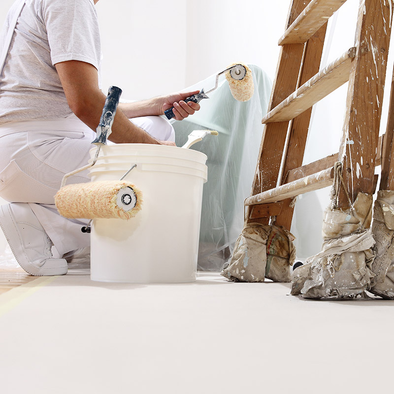 Painting with roller Painter painting a wall with a roller.